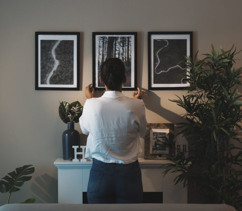 woman-arranging-paintings-home